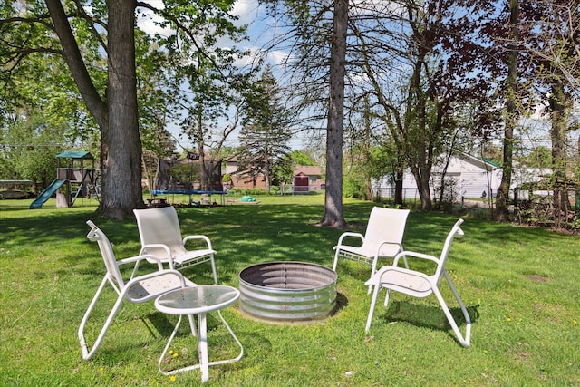 11389 Gold Arbor Rd, Plymouth, MI 48170 - view of yard with a trampoline, a playground, and an outdoor fire pit