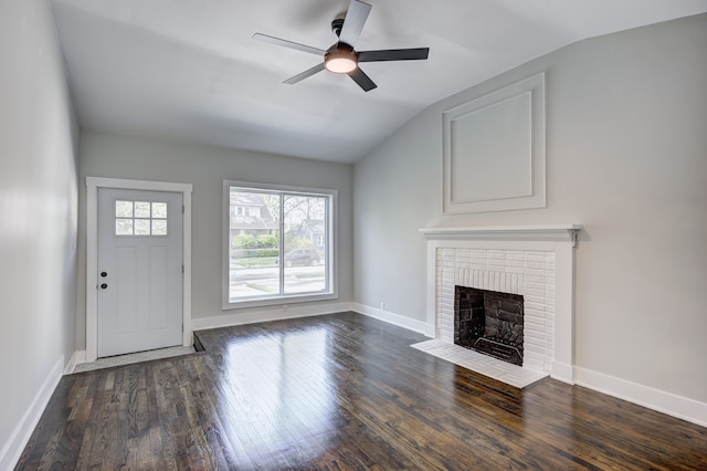 unfurnished living room with vaulted ceiling, a ceiling fan, a fireplace, and wood finished floors