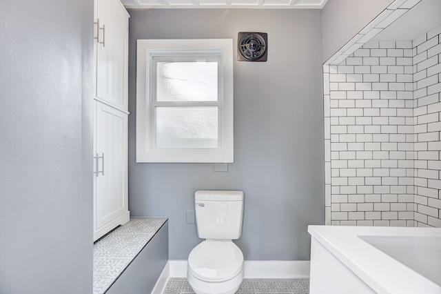 full bath featuring toilet and baseboards