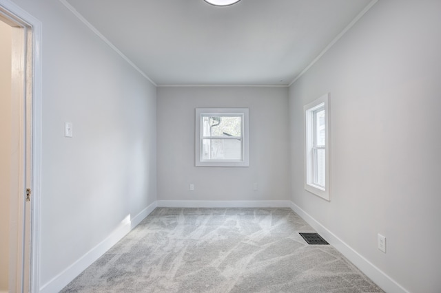 spare room featuring carpet floors, ornamental molding, and baseboards