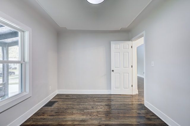 empty room featuring dark wood-type flooring and baseboards