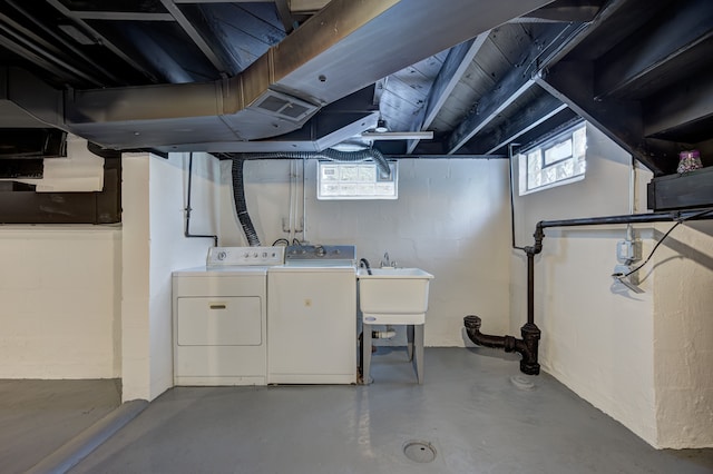 basement with separate washer and dryer, a sink, and concrete block wall