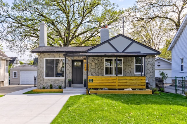 view of front of property featuring stone siding, an outbuilding, a chimney, a garage, and a porch