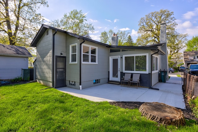 rear view of property with a chimney and a patio area