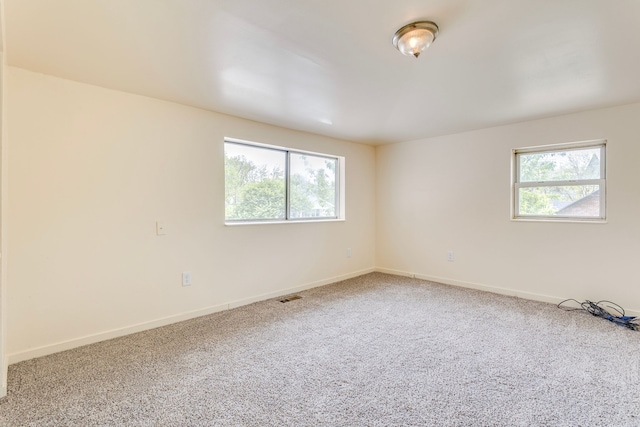 empty room featuring carpet and baseboards
