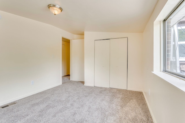 unfurnished bedroom with carpet flooring, a closet, and baseboards