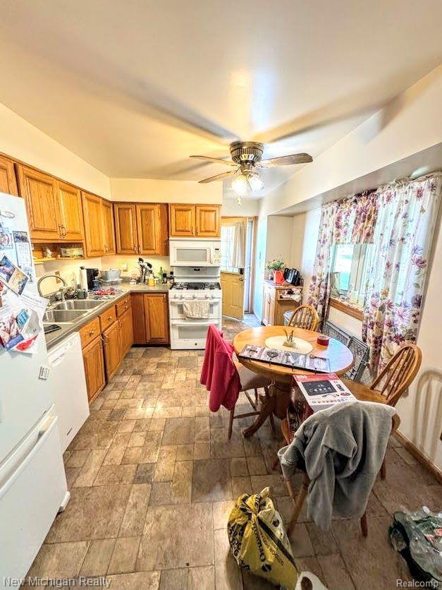212 Sunnybrooke Dr, Vernon, MI 48476 - kitchen with white appliances, a sink, light stone finish flooring, brown cabinetry, and a ceiling fan