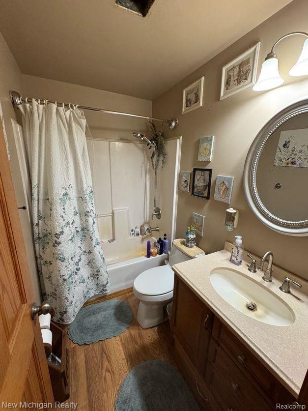 212 Sunnybrooke Dr, Vernon, MI 48476 - bathroom with wood finished floors, vanity, shower / bath combination with curtain, and toilet
