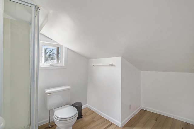 315 E Main St, Hart, MI 49420 - bathroom with lofted ceiling, toilet, baseboards, a shower stall, and wood finished floors