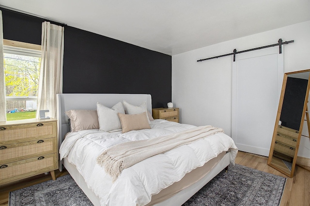 315 E Main St, Hart, MI 49420 - bedroom featuring a barn door and light wood-style flooring