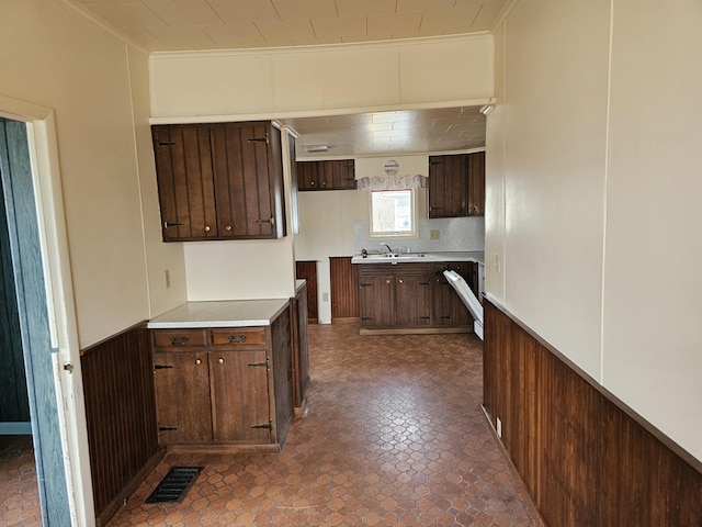 kitchen featuring ornamental molding, wainscoting, and visible vents