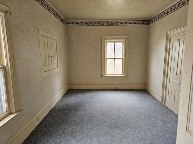 carpeted empty room with baseboards