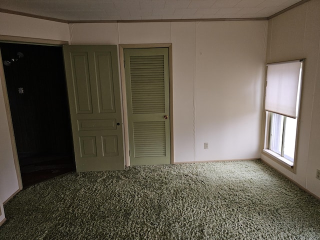 unfurnished bedroom featuring a closet, ornamental molding, and carpet