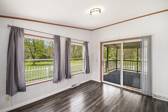 unfurnished room featuring baseboards, visible vents, and wood finished floors