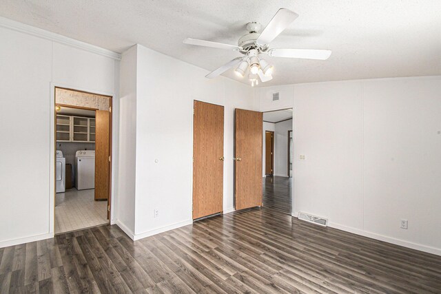 unfurnished bedroom with washer and dryer, visible vents, wood finished floors, and a ceiling fan