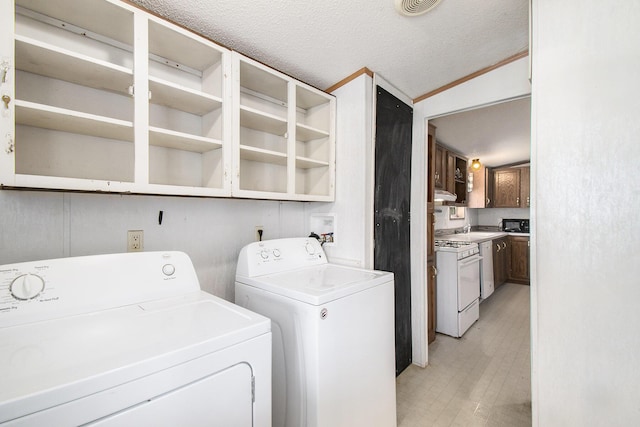laundry room featuring laundry area, a textured ceiling, and washing machine and dryer