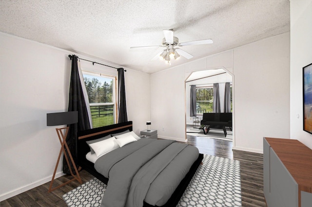 bedroom with a textured ceiling, multiple windows, baseboards, and dark wood-style floors