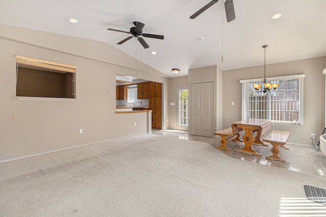living area featuring baseboards, lofted ceiling, ceiling fan with notable chandelier, and light carpet