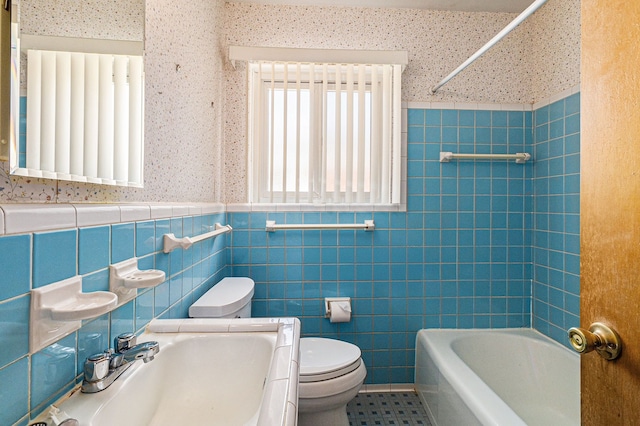 full bathroom with a sink, wainscoting, toilet, and tile walls