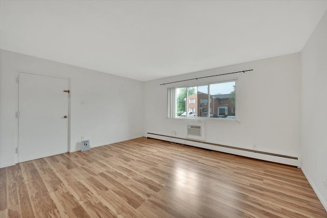 empty room featuring a baseboard heating unit, light wood-style floors, and baseboards