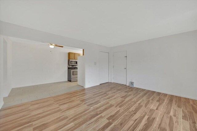 unfurnished living room with light wood-type flooring and a ceiling fan