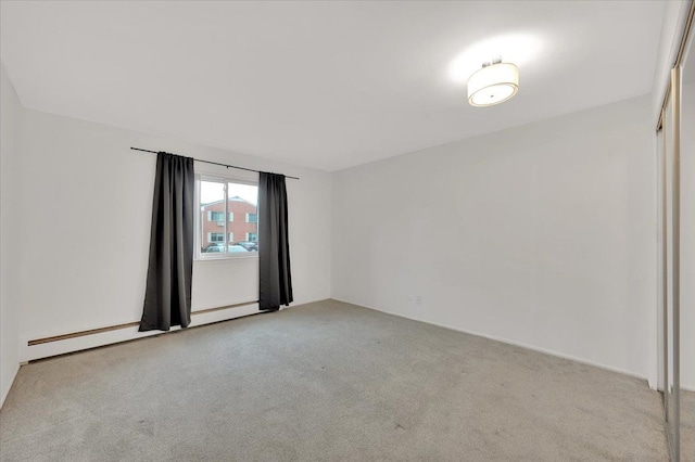 empty room featuring light colored carpet and a baseboard radiator