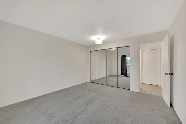 unfurnished bedroom featuring carpet and a closet