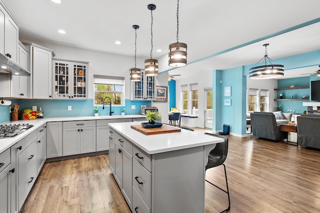 5849 Gavin Ln, Kalamazoo, MI 49009 - kitchen with stainless steel gas cooktop, a breakfast bar, ceiling fan, a sink, and open floor plan