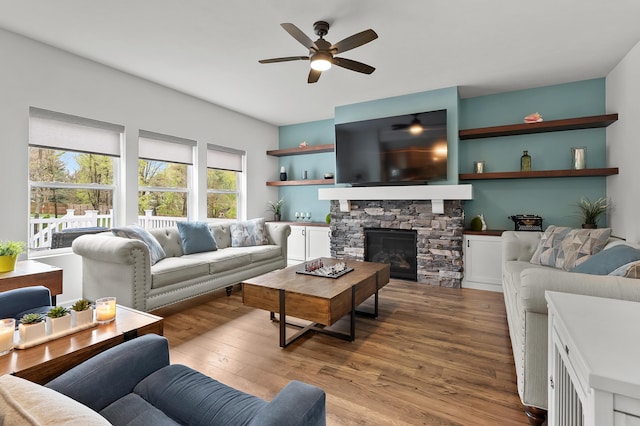 5849 Gavin Ln, Kalamazoo, MI 49009 - living area featuring a stone fireplace, ceiling fan, and wood finished floors