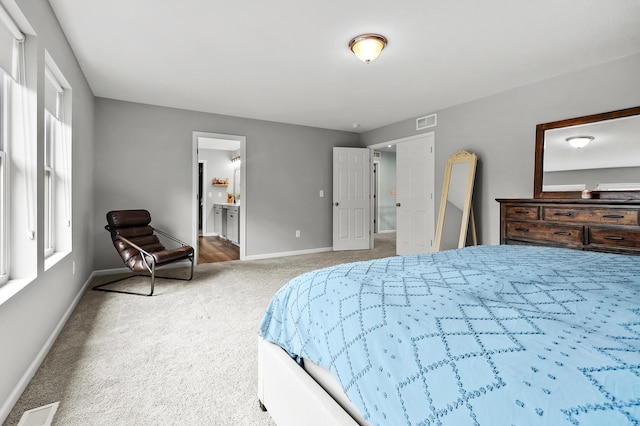 5849 Gavin Ln, Kalamazoo, MI 49009 - carpeted bedroom featuring baseboards, ensuite bathroom, and visible vents