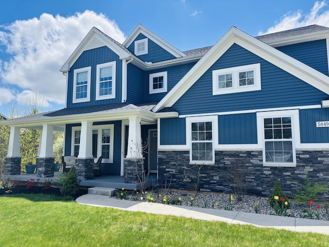 5849 Gavin Ln, Kalamazoo, MI 49009 - craftsman-style house with covered porch, a front lawn, stone siding, and board and batten siding