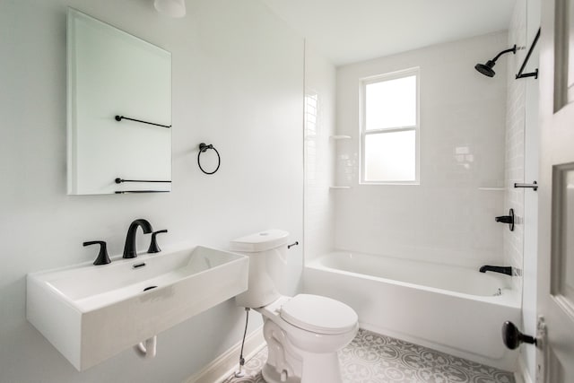 bathroom with toilet, a sink, shower / bath combination, baseboards, and tile patterned flooring
