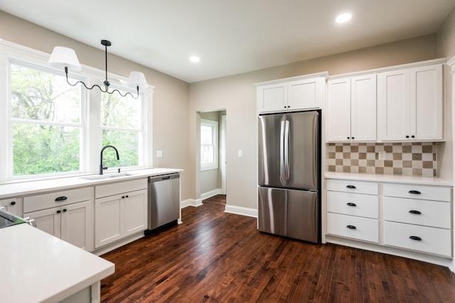 kitchen featuring light countertops, appliances with stainless steel finishes, dark wood-style floors, and a sink