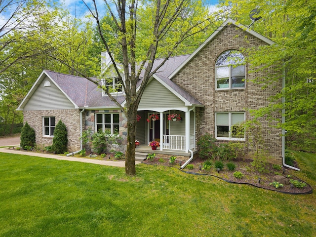 4217 Phillips Rd, Metamora, MI 48455 - view of front facade with covered porch, a front yard, brick siding, and roof with shingles