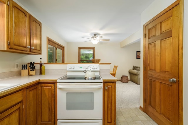 4217 Phillips Rd, Metamora, MI 48455 - kitchen featuring white electric range, a peninsula, brown cabinetry, and light countertops