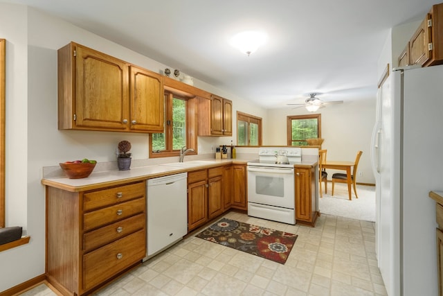 4217 Phillips Rd, Metamora, MI 48455 - kitchen with white appliances, a peninsula, light countertops, ceiling fan, and brown cabinets