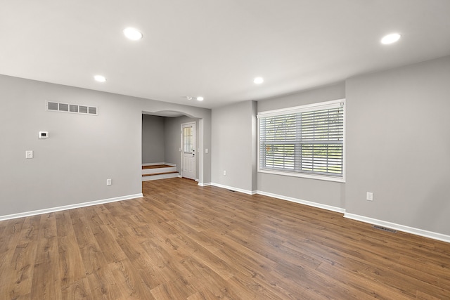 4125 Newton Rd, Commerce Twp, MI 48390 - empty room with arched walkways, recessed lighting, baseboards, and wood finished floors