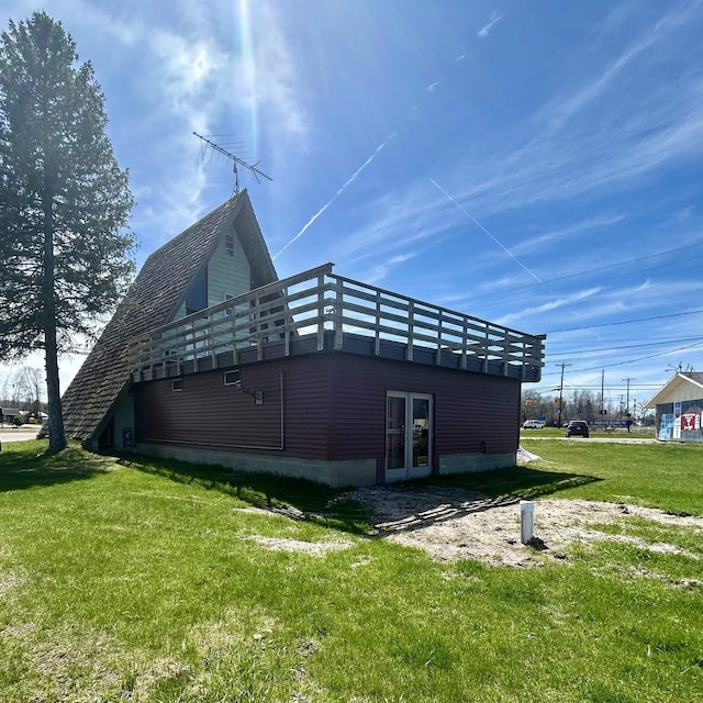 8874 W Houghton Lake Dr, Houghton Lake, MI 48629 - view of side of home featuring french doors, a deck, and a lawn