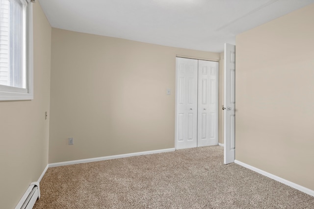 2703 Green Meadows Dr, Traverse City, MI 49685 - unfurnished bedroom featuring a baseboard heating unit, carpet flooring, and baseboards