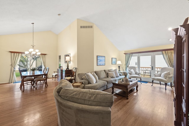 living area with plenty of natural light, a chandelier, and high vaulted ceiling
