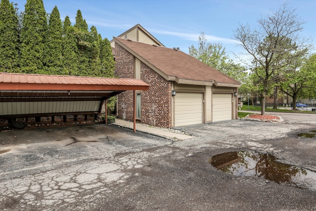 garage featuring asphalt driveway