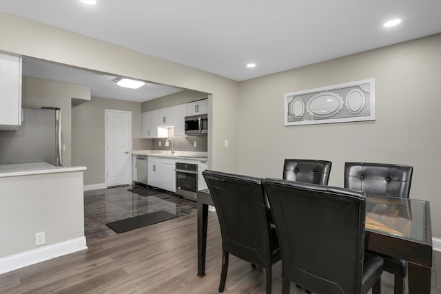 dining room featuring baseboards, dark wood-type flooring, and recessed lighting