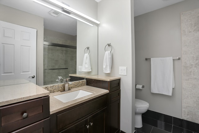full bathroom featuring a tile shower, toilet, vanity, and tile patterned flooring