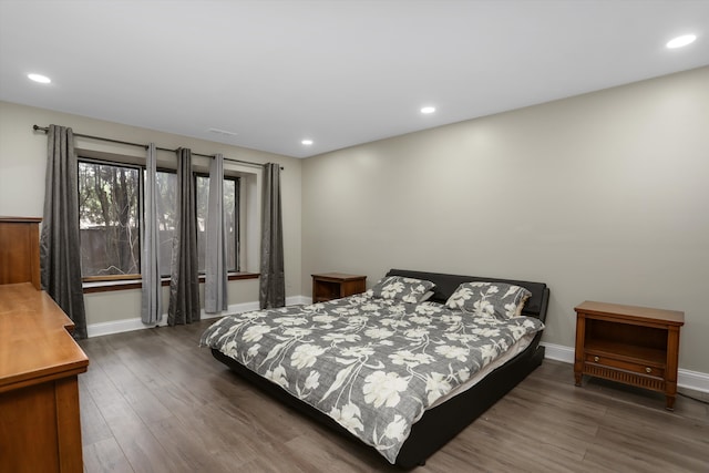 bedroom featuring wood finished floors, baseboards, and recessed lighting