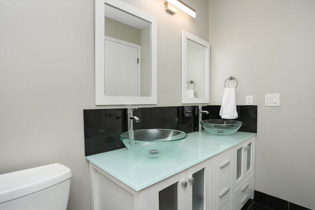 bathroom featuring double vanity and toilet