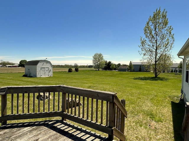 deck with a shed, an outdoor structure, and a yard