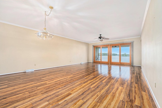 empty room featuring baseboards, wood finished floors, ceiling fan with notable chandelier, and ornamental molding