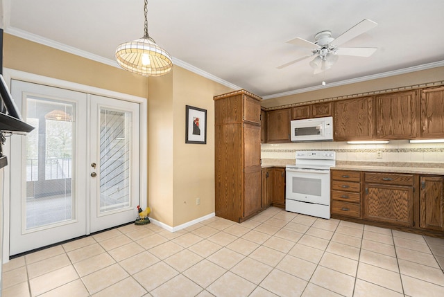 kitchen with light tile patterned floors, french doors, brown cabinetry, white appliances, and ornamental molding