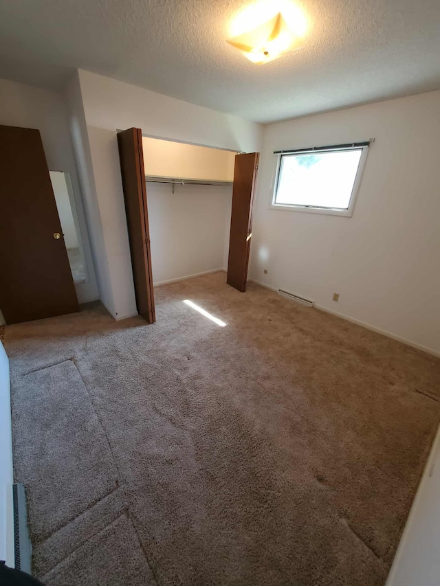 854 Kelley St, Traverse City, MI 49686 - unfurnished bedroom featuring a textured ceiling, light carpet, a closet, and baseboards