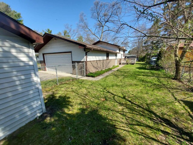854 Kelley St, Traverse City, MI 49686 - view of yard with an attached garage, concrete driveway, and an outbuilding
